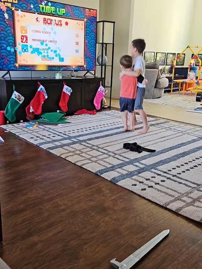 Two boys celebrating a high score in front of the TV