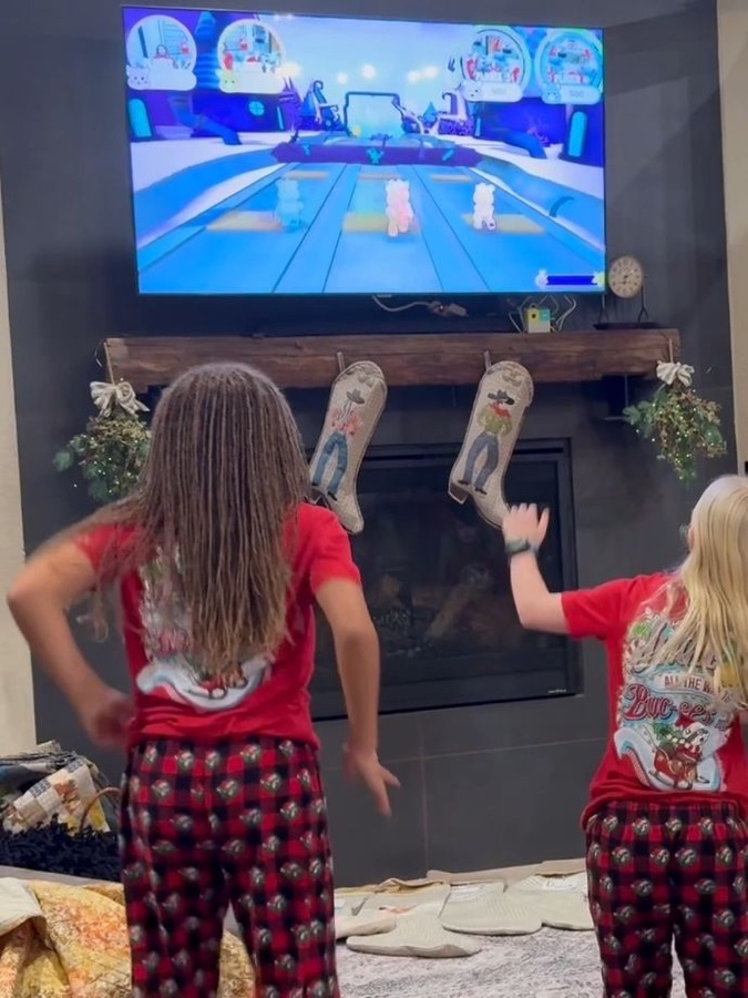 Two girls in pyjamas dancing in front of the fireplace