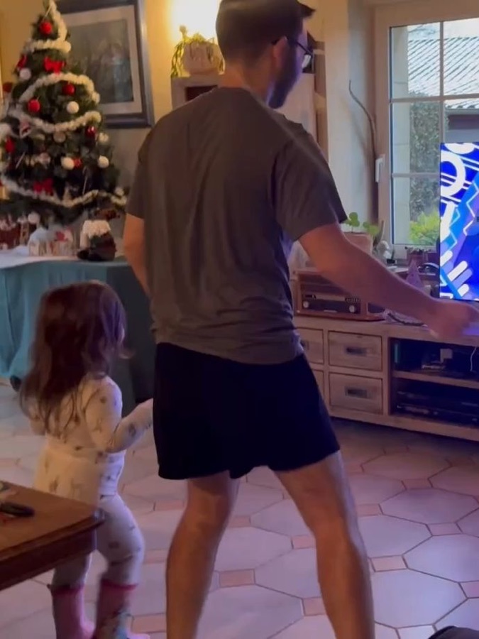 Dad and toddler playing together by the Christmas tree