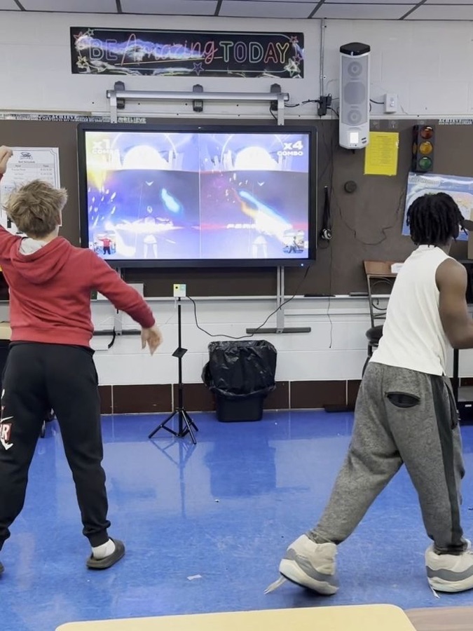 Two pupils playing a motion game in a classroom